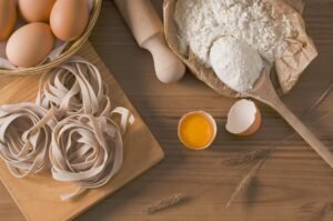 Fresh pasta, eggs and flour on a wooden table