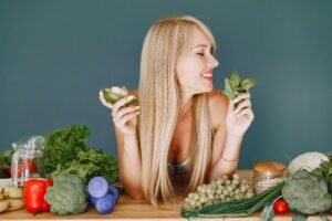 Woman holding vegetables and cutlery