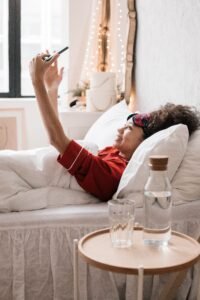 Person Lying in bed holding a smartphone